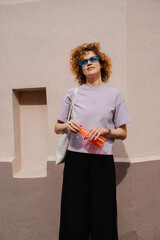 Joyful woman stretching arms up in lavender t-shirt