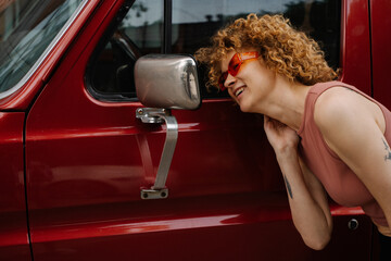 Woman Laughing and Looking into Mirror of Red Van