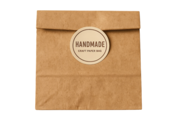 Handmade craft paper bag with round sticker label isolated on white or transparent background, eco packaging for gift or product branding