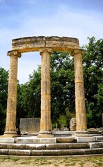 Ruins and remains of the Philippeion, a tholos in ancient Olymipia, Greece. Statues of Alexander the Great and his family were kept here. A colonnade of ancient columns surrounds the temple