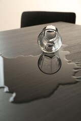 Overturned glass and spilled water on wooden table