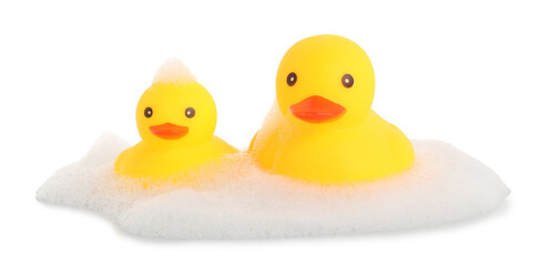 Cute rubber ducks and foam isolated on white