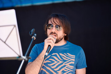 Rock band vocalist performing on stage during an outdoor festival event