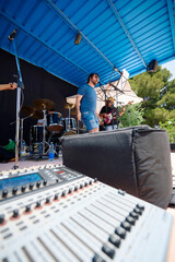 Rock band performing live on an outdoor stage during a summer festival