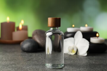 Composition with cosmetic product and spa stones on grey table, closeup