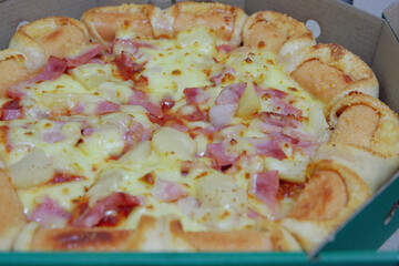 pizza with ham, by cut to pieces on table. selective focus on the filling close-up.
