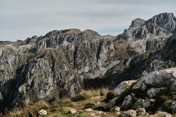 Towering peaks of Prokletije mountains in Montenegro country with jagged rock faces under dramatic overcast sky.