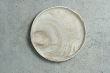 A white ceramic plate, pottery plate on gray background. Textured, handmade, empty plate concept....