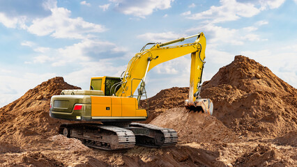 Excavator working on soil at a construction site under a clear sky during daytime