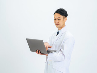 ノートパソコンを使う白衣のミドルエイジ男性　医師　科学者