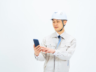 スマホを使う作業服を着たミドル男性