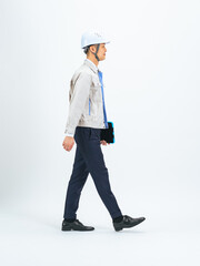 Full-body photo of a middle-aged man wearing work clothes walking