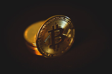 A shiny golden Bitcoin stands out in close-up, symbolizing cryptocurrency, digital finance,...