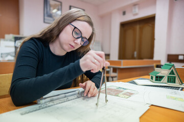 Caucasian young woman making drawings. Student of architecture university. 
