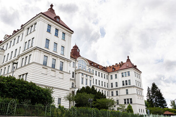 Historic rectorate of Brno University of Technology, white Neo-Renaissance fa&ccedil;ade with red mansard roofs against cloudy sky 
