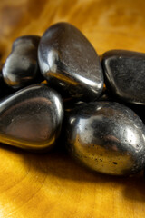 Pile of black rocks on a wooden surface. The rocks are shiny and metallic in appearance. Concept of mystery and intrigue, as the rocks seem to hold some hidden meaning or purpose