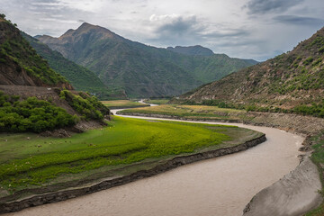 Siran River Valley with Mountains and Grazing Sheep in Pakistan