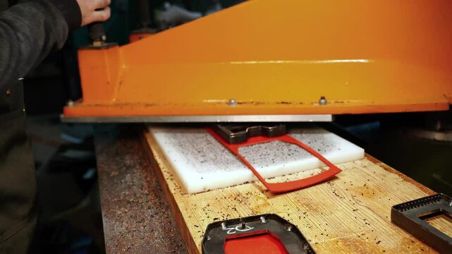 Leather wallet shape cut with metal die press in workshop