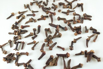 Scattered dried cloves on a clean white background. Ideal for food, spice, herbal medicine, and...