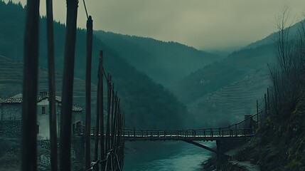 Suspension bridge over a serene river in a mountainous region, creating a sense of tranquility and