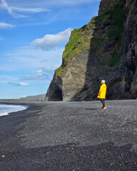 Majestic cliffs and black sand at Reynisfjara Beach in Iceland during a bright sunny day