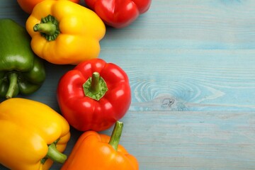 Fresh colorful bell peppers on blue wooden table, flat lay. Space for text