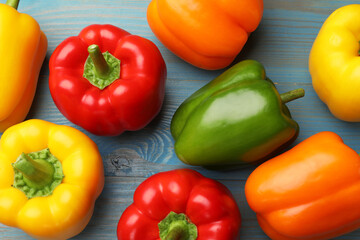 Fresh colorful bell peppers on blue wooden table, flat lay