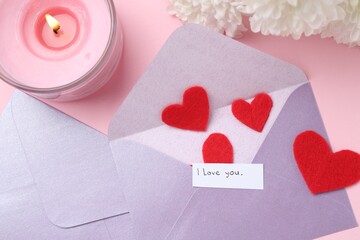 Envelopes with phrase I Love You, red hearts, burning candle and flowers on pink background, flat...