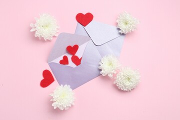 Love letters, flowers and red hearts on pink background, flat lay