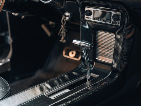 Close-up interior view of a classic American muscle car automatic transmission shifter with chrome finish and vintage radio &ndash; retro automotive design captured for restoration, martketing press.