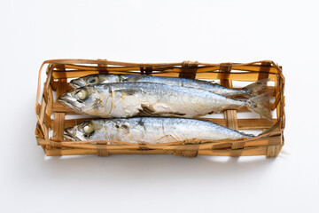 Ikan pindang in bamboo basket, Indonesian traditional fresh salted fish on white table