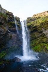 Obraz premium Majestic Kvernufoss waterfall cascading amidst lush cliffs in Iceland