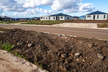 A suburban street in Wyndham Vale, Melbourne, showing unfinished landscaping, vacant residential...
