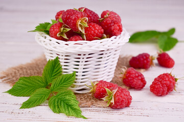 Fresh raspberries in a white basket. Close-up.
