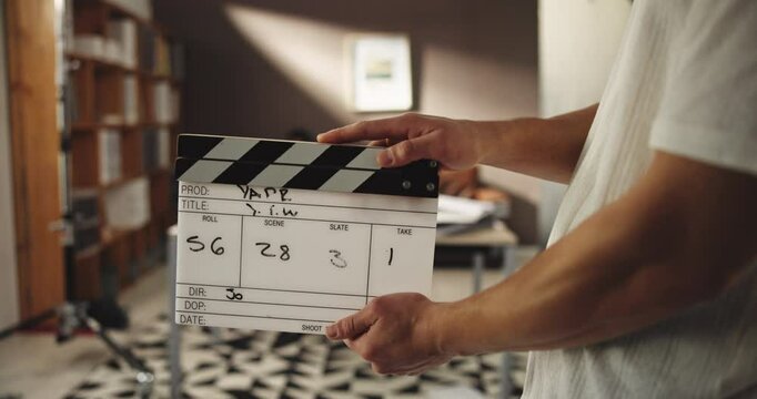 Filming, production and hands with clapboard on set for photography, video recording or movie scene. Audio sync, backstage and person with slate for photoshoot action, content and behind the scenes