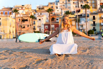 Argentine woman meditating on the beach at sunrise in villajoyosa, spain