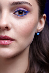 Fototapeta premium Closeup portrait of female face. Human woman half-face with unusual beauty blue eye lashes makeup.