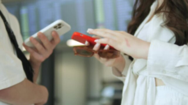 Two people are holding cell phones and one of them is wearing sunglasses. Scene is casual and relaxed