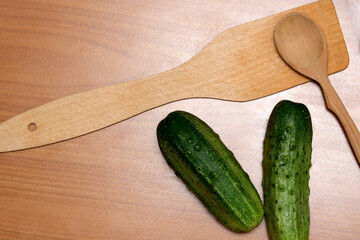 Cucumbers and wooden tools await prep on the countertop