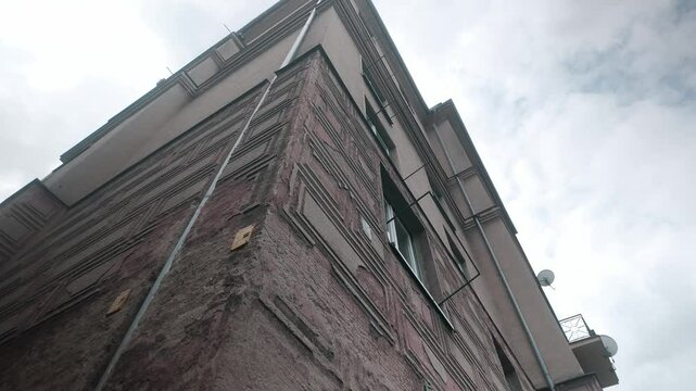 Looking up to urban Soviet built residential corner apartment block