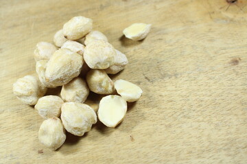 Raw candlenuts on a wooden background. Perfect for food photography, culinary ingredients, and traditional cooking concepts