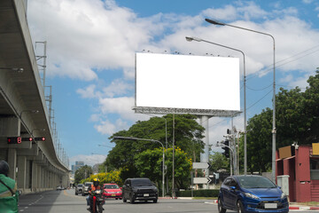 Blank billboard with blue sky background over traffic road in city street for urban outdoor advertisement mockup