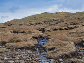 Remote wetland on Muckle Roe with gentle slopes and a serene atmosphere under a vast sky.
