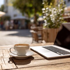 A cup of coffee with a laptop in a terrace in the city.