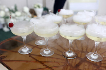 Glasses of white champagne with smoke. Festive reception.