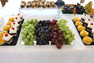 Fruit and cakes on a festive buffet table.