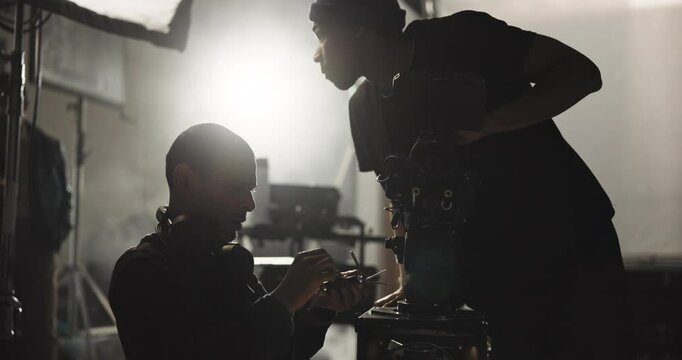 Film, maintenance and men with camera in studio for lens adjustment, process and equipment settings. Cinematography, operator and videographer with assistant for shooting, production and filmmaking