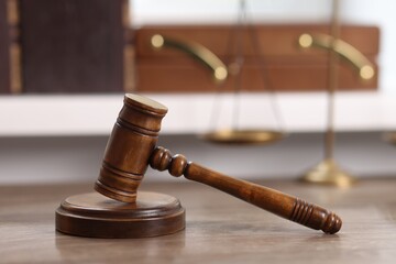 Judge. Gavel and scales on wooden table in office, selective focus