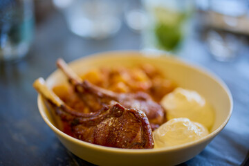 a plate of lamb ribs with sauce and potato stew