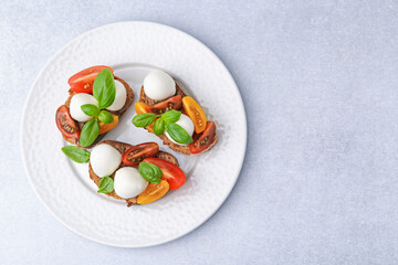 Tasty sandwiches with mozzarella cheese, tomatoes and basil on white table, top view. Space for text